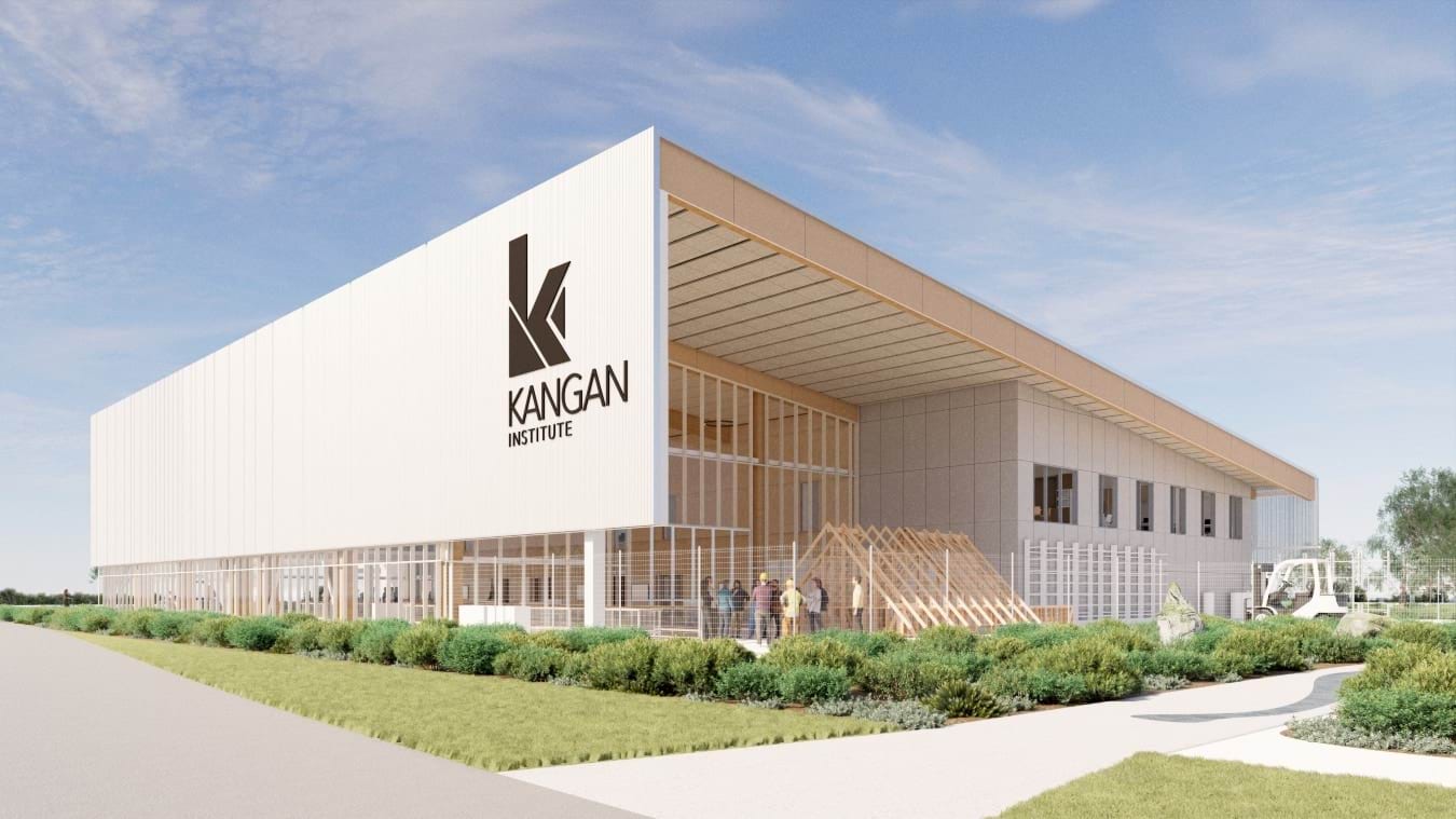 An artist's render of the exterior of the Kangan Institute building, featuring a modern design with large glass panels and a light-coloured facade. Landscaped areas surround the building.
