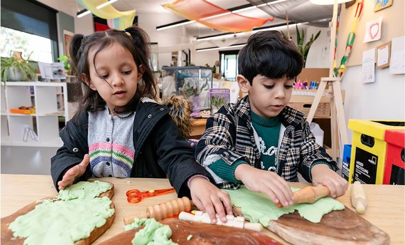 Two children playing with playdough.