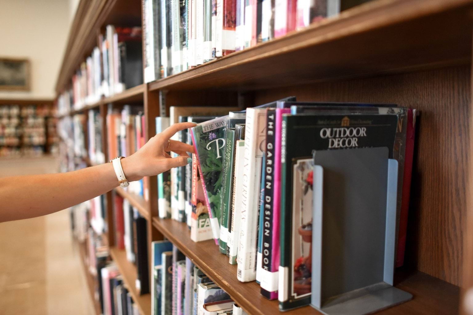 Hand choosing book off shelf