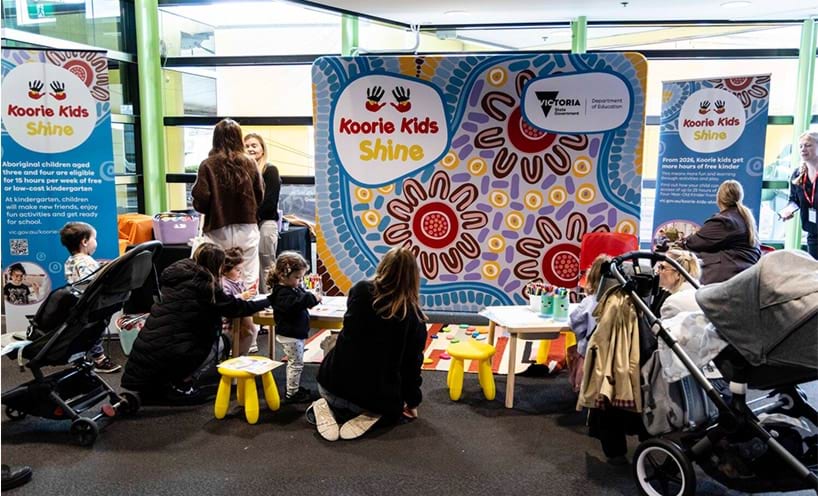 Parents and children interacting with the Koorie Kids Shine information stand.