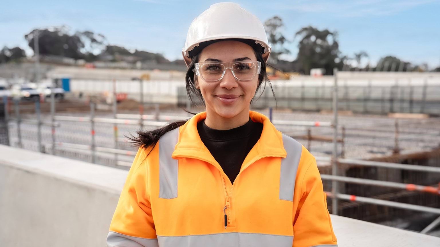 Construction worker looking at camera wearing hard hat and high vis vest