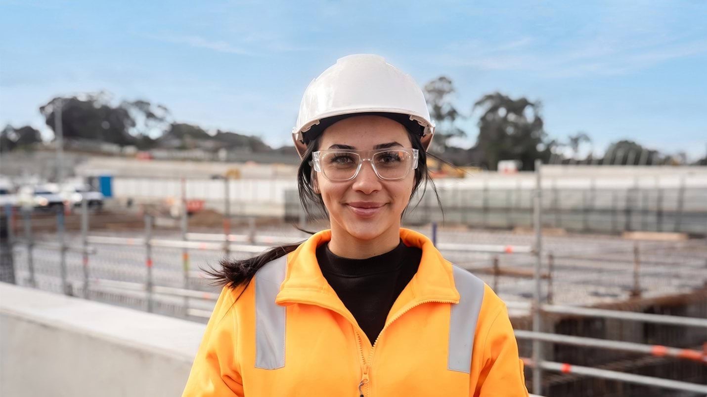 Construction worker looking at camera wearing hard hat and high vis vest